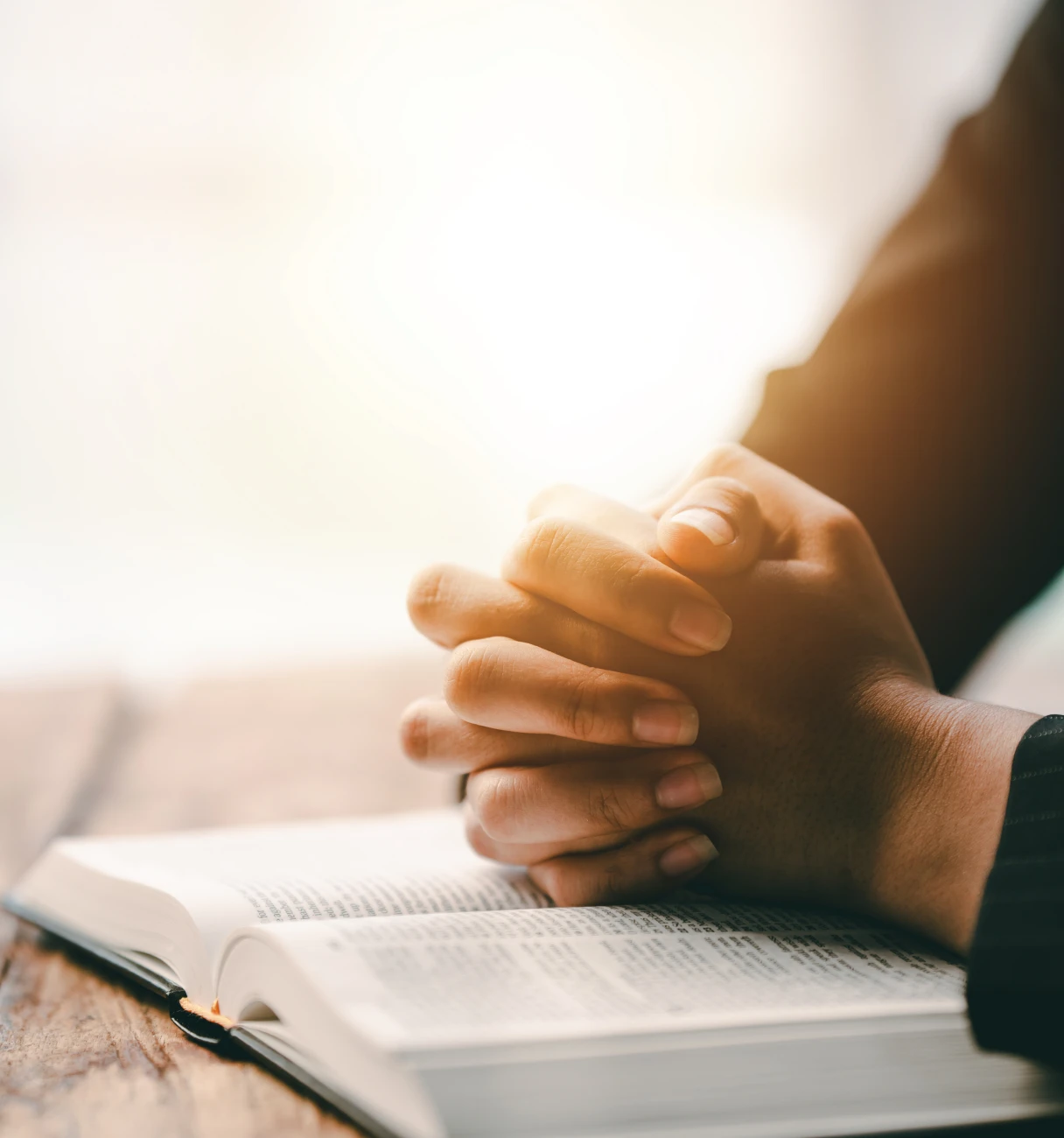Peaceful reflection with hands on open book